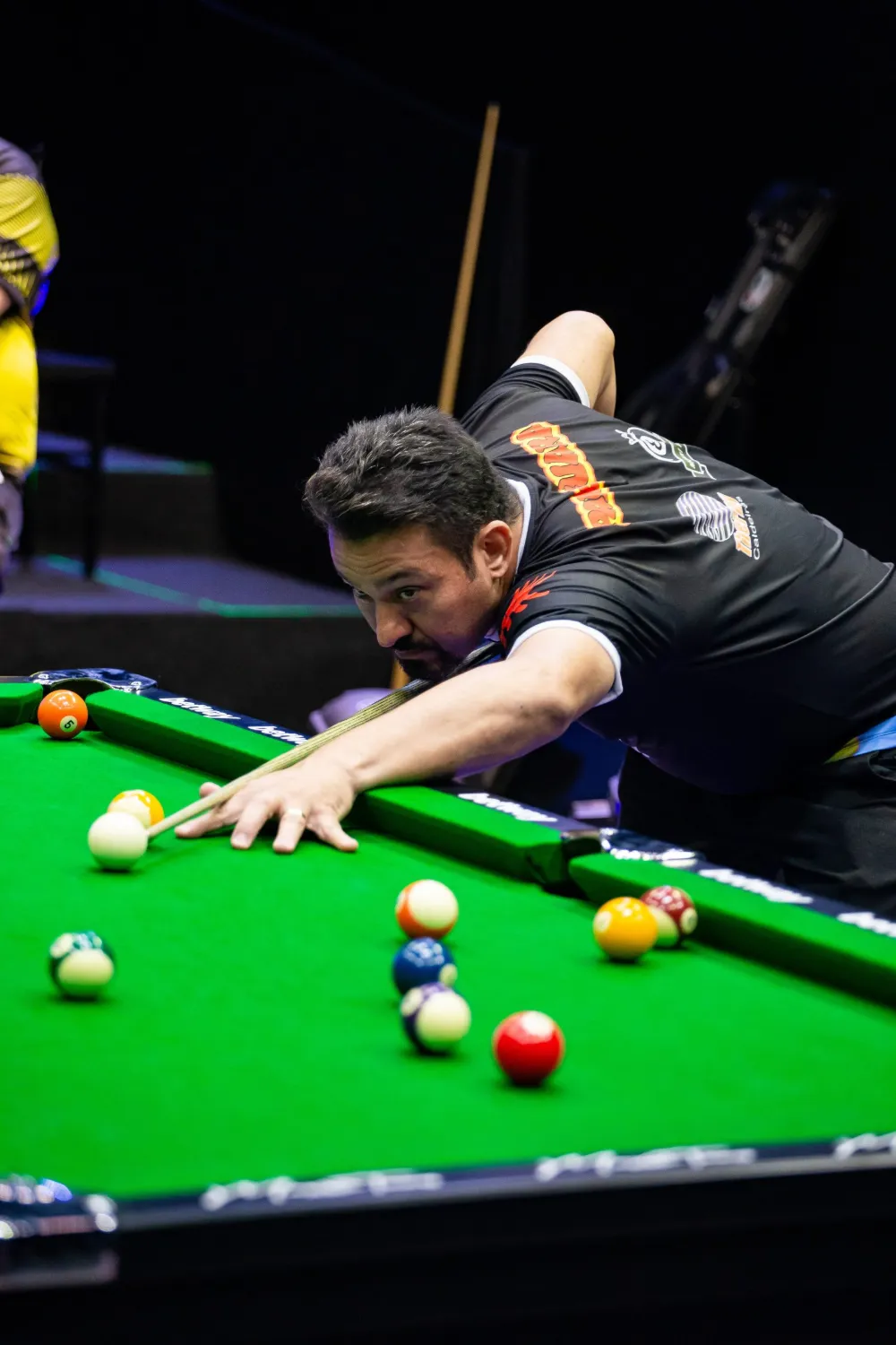 Noel Snooker em campeonato, debruçado sobre a mesa mirando