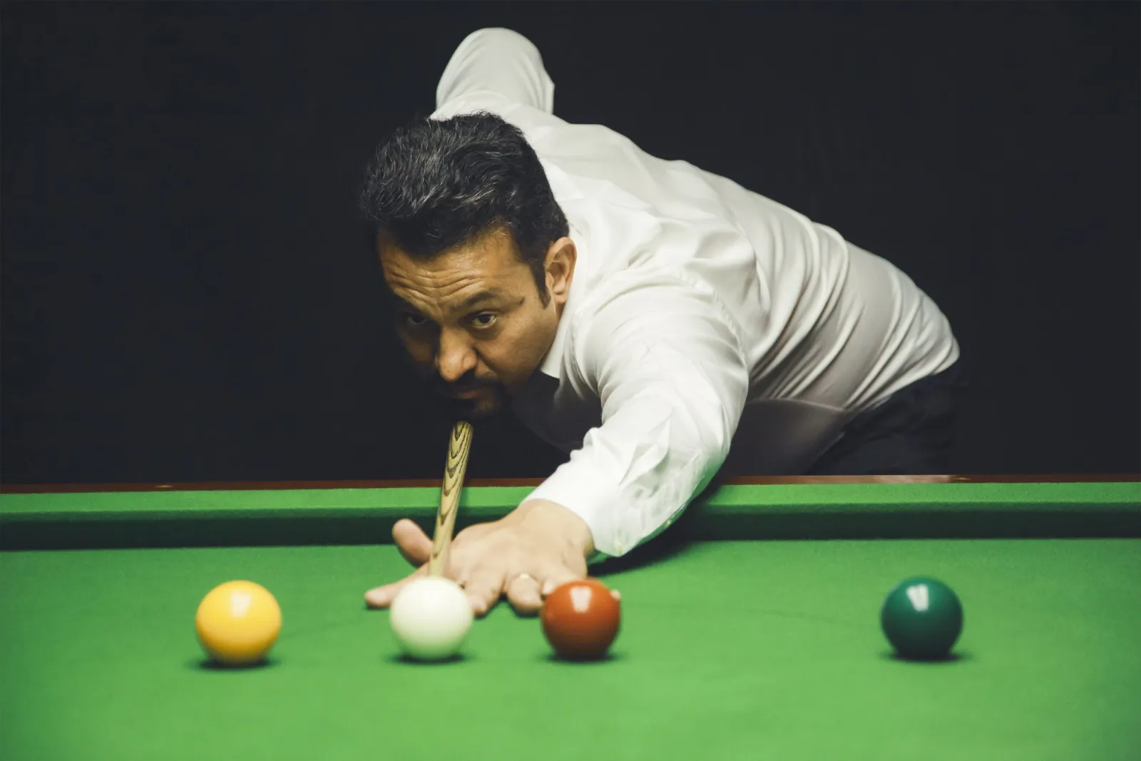 Noel Snooker mirando a bola branca na mesa de sinuca
